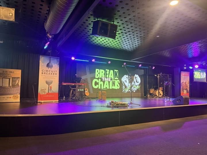 Venue stage set for a live performance with keyboard, guitars and drum kit